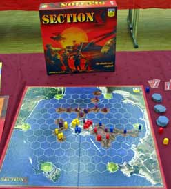 Photo of box and board of Section X showing counters and tiles in play